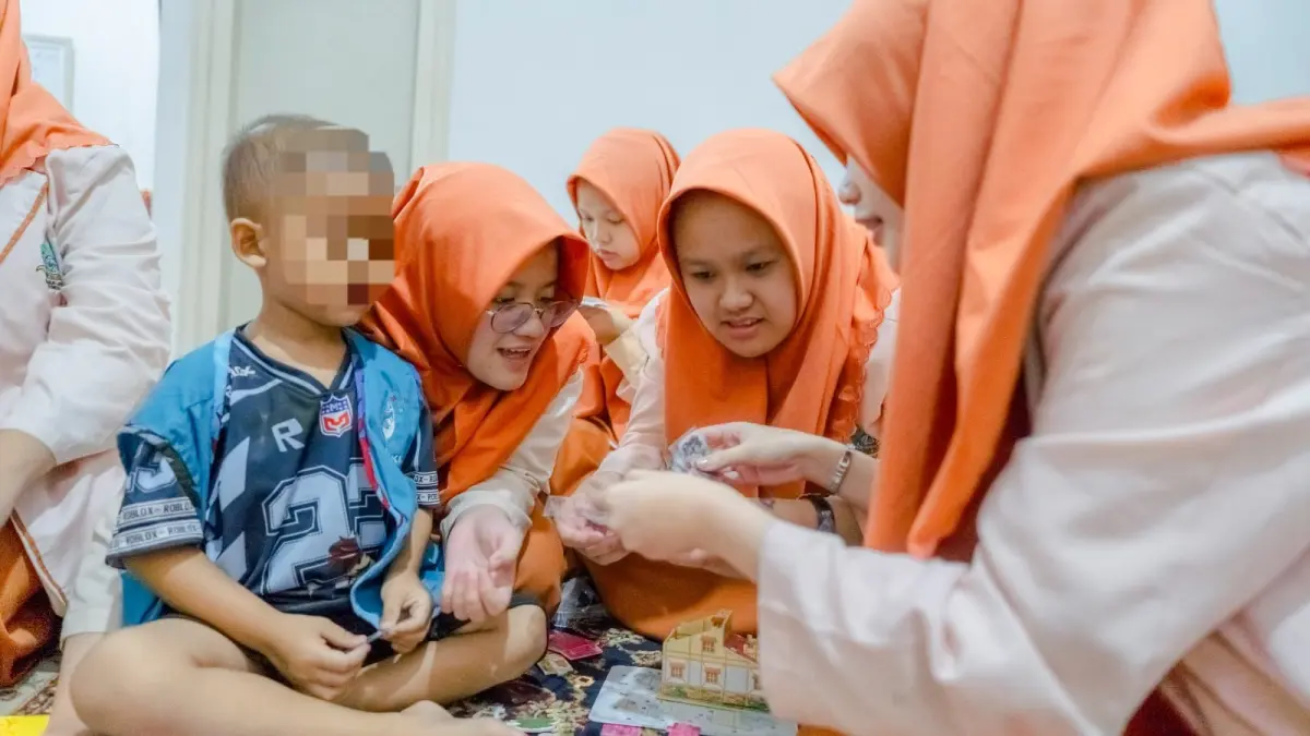 BELAJAR: Siswa SMA Progresif Bumi Shalawat bermain bersama salah satu penderita kanker di Yayasan Kasih Anak Kanker Indonesia (YKAI) Surabaya.