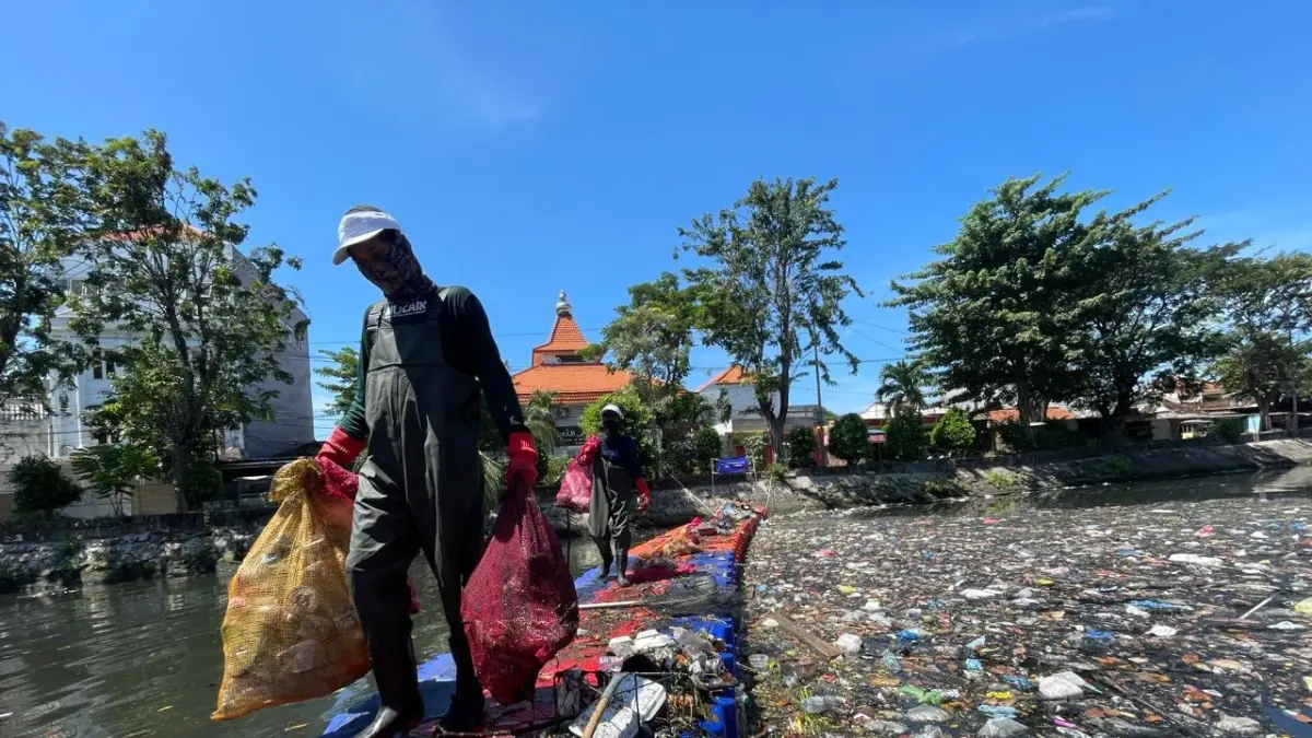 Petugas membawa sampah yang diambil dari Kali Tebu, Kenjeran. (RAHMAT SUDRAJAT/RADAR SURABAYA)