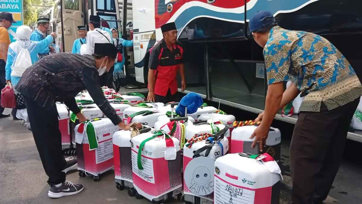 Koper besar jemaah haji dari daerah saat tiba di Embarkasi Surabaya diperiksa karena dikhawatirkan membawa barang yang dilarang. (Rahmat Sudrajat/Radar Surabaya)