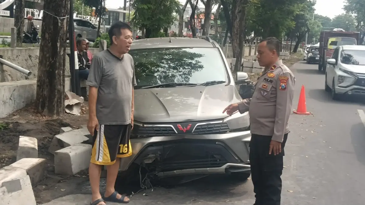 PENYOK: Kondisi mobil usai menabrak pembatas di Jalan Raya Menganti, Wiyung, Surabaya.(IST/RADAR SURABAYA)