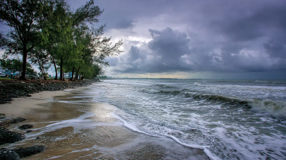 Ilustrasi hujan ringan di pesisir pantai. (AI)