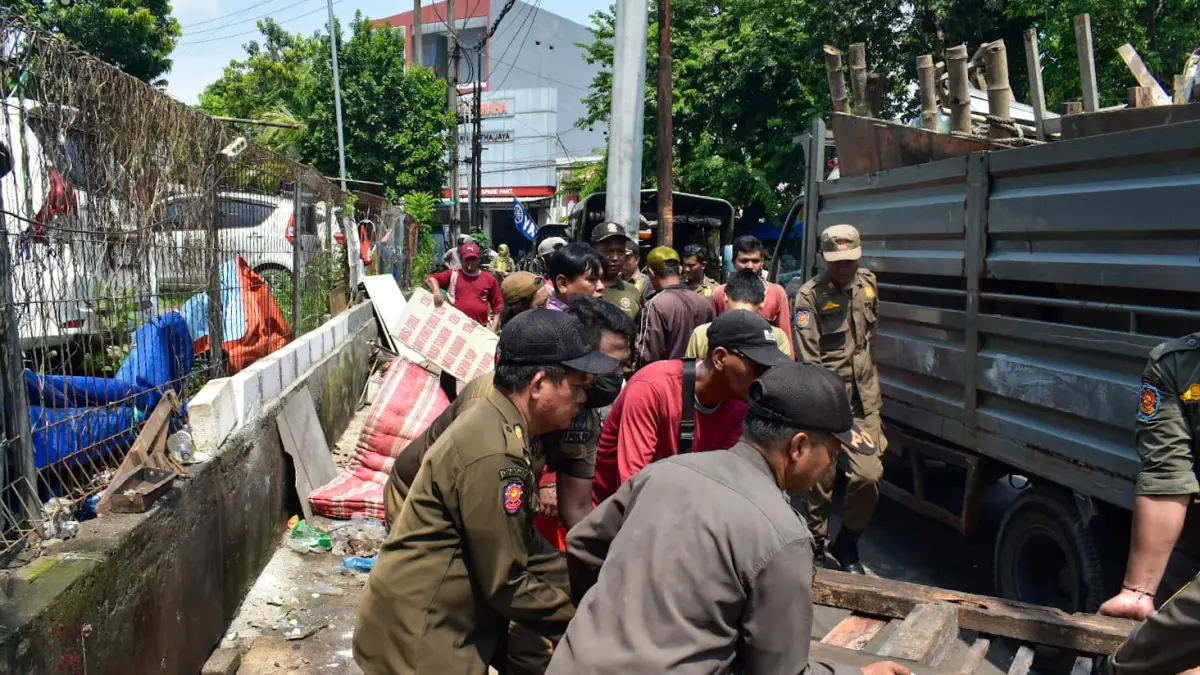 Petugas membongkar lapak PKL di Jalan Kali Kepiting Surabaya. (IST)