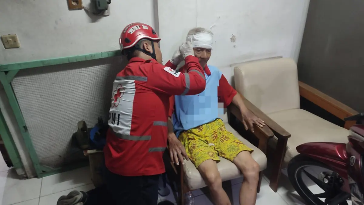 PERTOLONGAN: Petugas saat mengobati korban. Ia menjadi korban perampokan rumah dan toko emas di Jalan Pasar Baru Wonokromo, Surabaya. (IST/RADAR SURABAYA)
