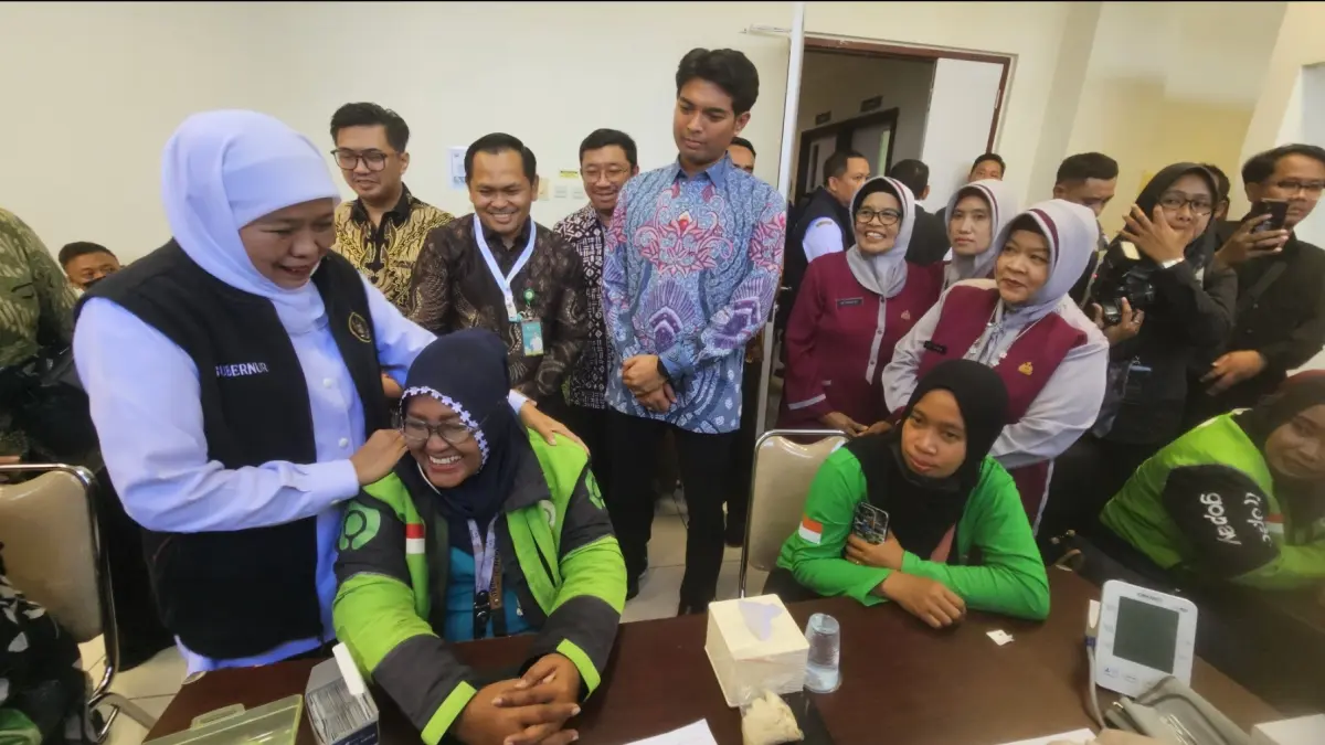 Gubernur Jatim, Khofifah Indar Parawansa menyapa pengemudi ojol yang berpartisipasi dalam pengecekan kesehatan gratis.