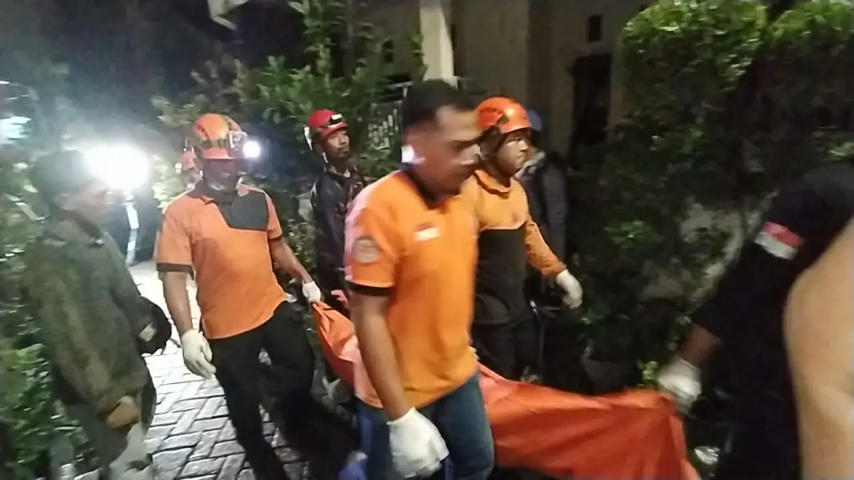 EVAKUASI: Petugas saat membawa jenazah salah satu korban kebakaran. Dua orang meninggal cucu dan nenek akibat kebakaran tersebut.(IST/RADAR SURABAYA)