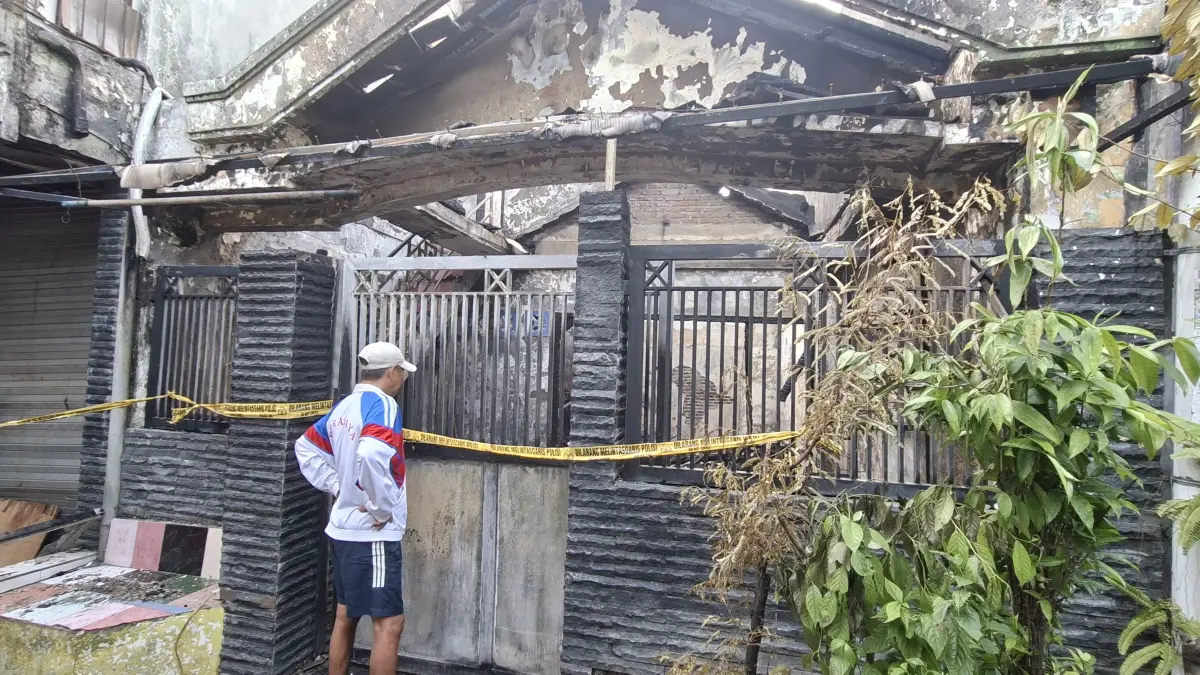 HANGUS: Kondisi rumah di Jalan Banyu Urip Kidul, Surabaya, usai kebakaran. Dua orang meninggal dunia, lokasi diberi garis polisi.(MAHRUS/RADAR SURABAYA)