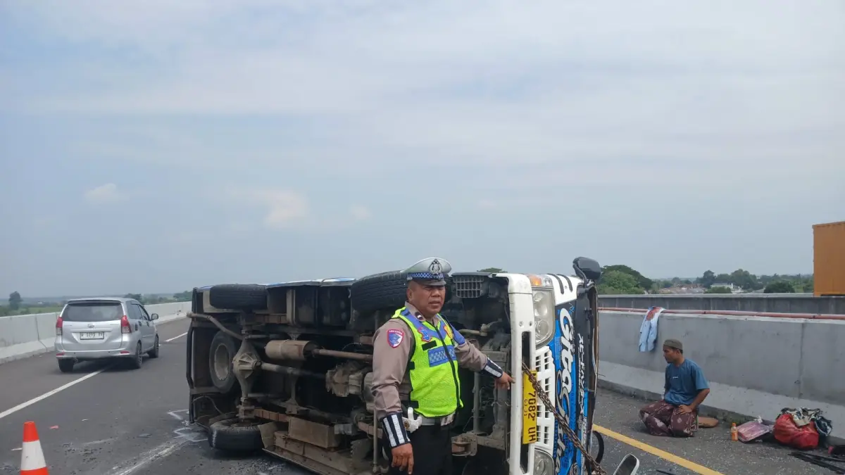 BELUM DIEVAKUASI: Mobil Elf yang mengangkut rombongan asal Sampang, Madura, terguling di Tol Jombang.(IST/RADAR SURABAYA)