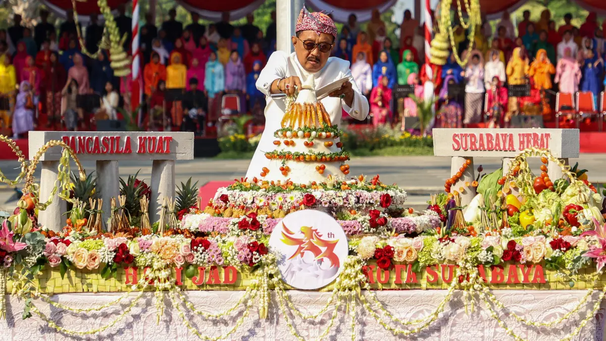 Plh Wali Kota Surabaya, Armuji memotong tumpeng dalam upacara HJKS ke-733 di Halaman Balai Kota, Minggu (31/5). (HUMAS PEMKOT SURABAYA)