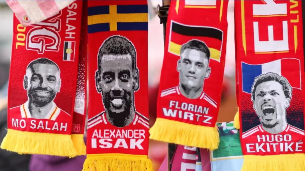 Syal-syal Liverpool yang menampilkan wajah Mohamed Salah, Alexander Isak, Florian Wirtz, dan Hugo Ekitiké, yang masing-masing menyisakan persoalan bagi sosok yang akan menggantikan posisi tersebut. (The Guardian)Matt McNulty/Getty Images). 