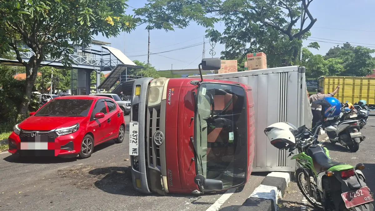 LAKA TUNGGAL : Kondisi truk boks terguling di putar balik selatan Bundaran, Taman Pelangi, Jalan Ahmad Yani, Surabaya, Selasa (2/6).(M MAHRUS/RADAR SURABAYA)