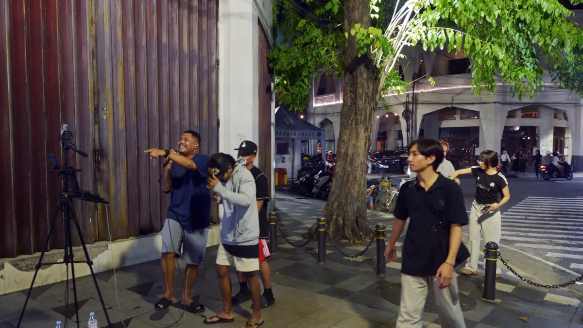 Brian Stefanus membuat live streaming TikTok di Jalan Tunjungan Surabaya. Hobi yang menghasilkan uang. (ANDY SATRIA/RADAR SURABAYA) 