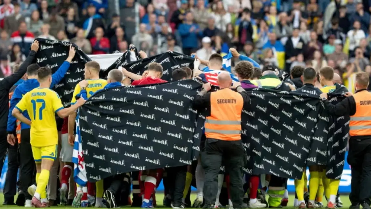 Pemain dan staf membentuk barikade menggunakan layar di sekeliling Christian Eriksen saat ia menerima perawatan medis di lapangan di Odense.(ThenGuardian/Bo Amstrup/Ritzau Scanpix Foto/AP). 