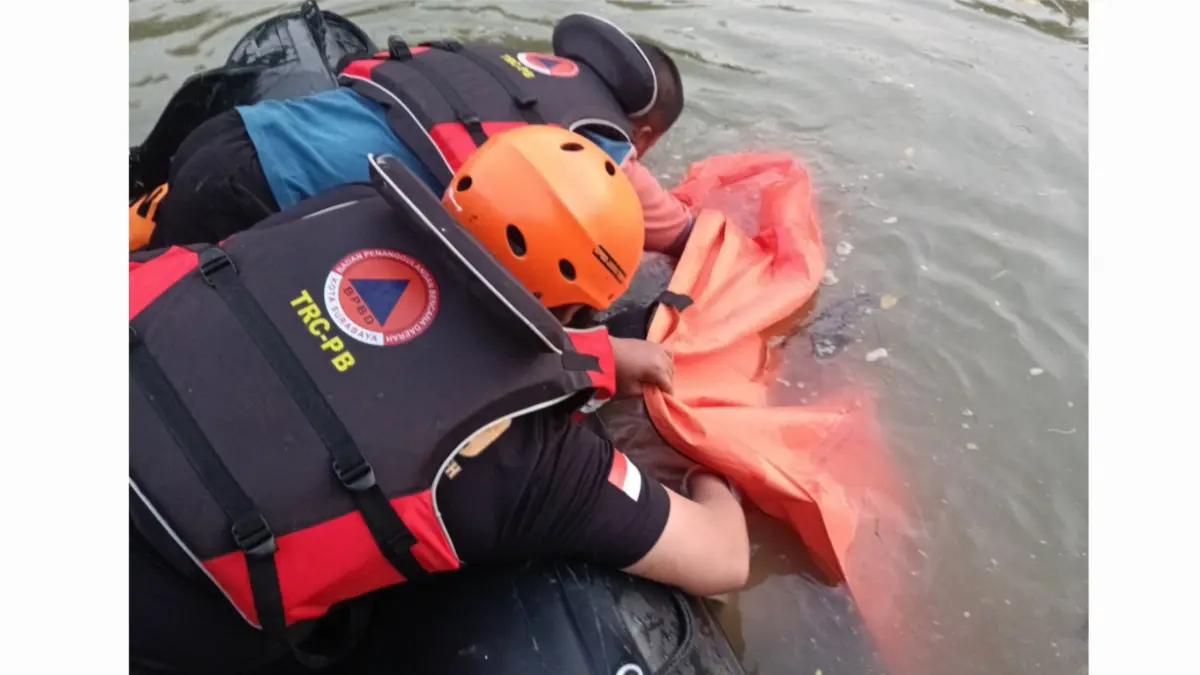 DITEMUKAN: Petugas mengevakuasi jasad pemancing yang tenggelam di Sungai Romokalisari, Surabaya. Korban ditemukan meninggal dunia di Kebomas, Gresik.(IST/RADAR SURABAYA)