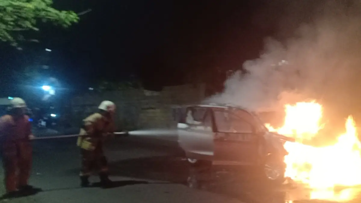 MENYALA: Petugas DPKP Surabaya saat memadamkan mobil yang terbakar di Jalan Citra Raya, Surabaya. (IST/RADAR SURABAYA)