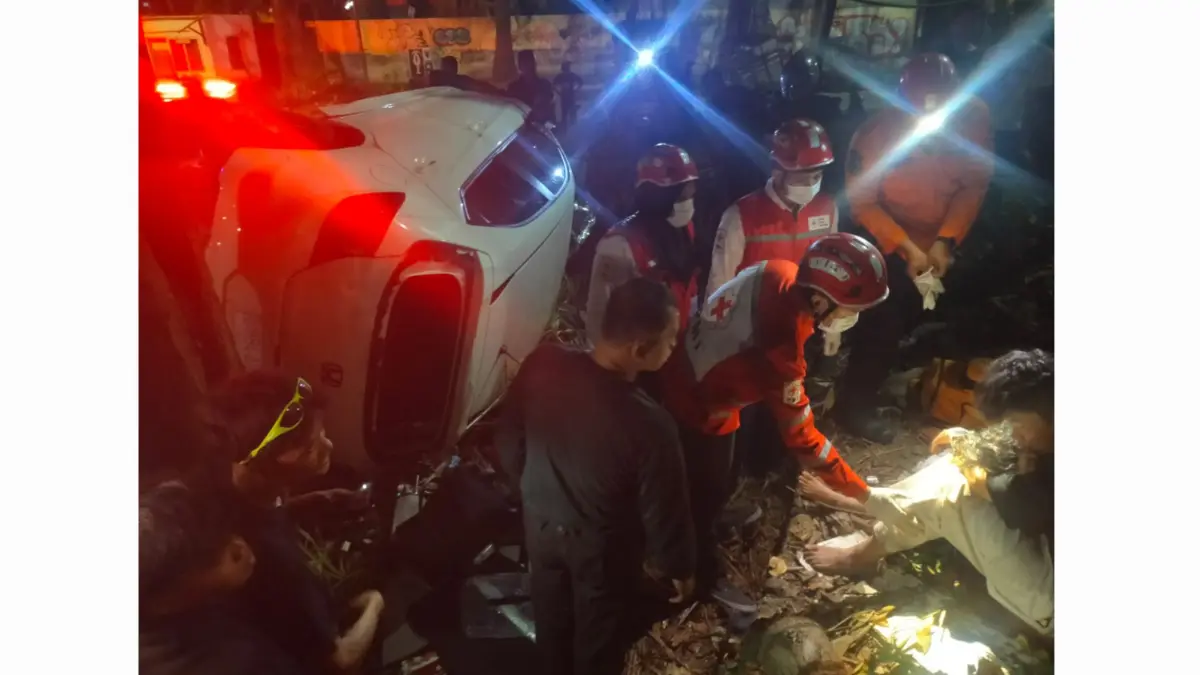 SYOK: Pengemudi dan temannya usai mobil yang dikemudikan terjun dari flyover Jalan Gubeng Pojok, Surabaya. (IST/RADAR SURABAYA)