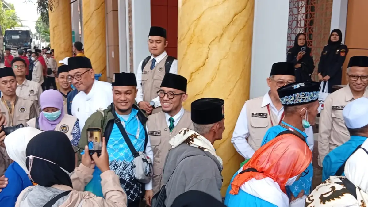 SENANG: Wamenhaj Dahnil Anzar Simanjuntak (tengah) saat menyapa jemaah haji kloter 44 yang tiba di Asrama Haji Debarkasi Surabaya, Jumat (12/6). (Rahmat Sudrajat/Radar Surabaya)