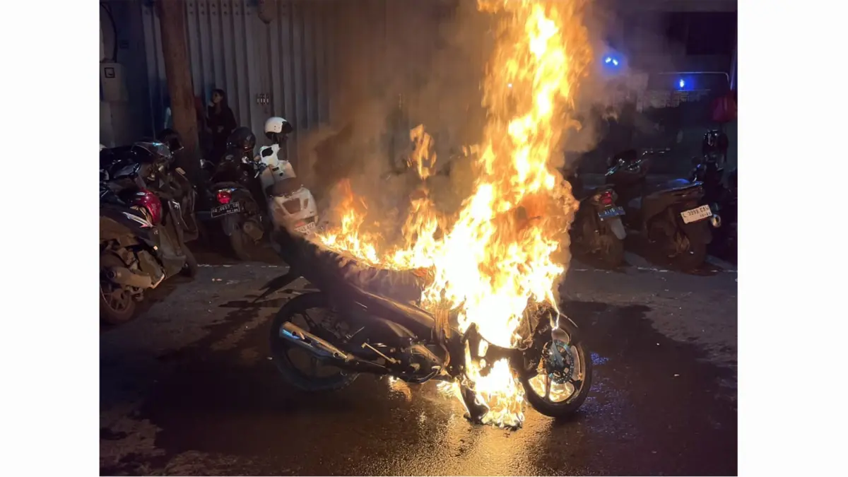 MENYALA : Kondisi motor milik Rian terbakar di Jalan Genteng Besar, Surabaya, Sabtu (13/6) malam.(IST/RADAR SURABAYA)