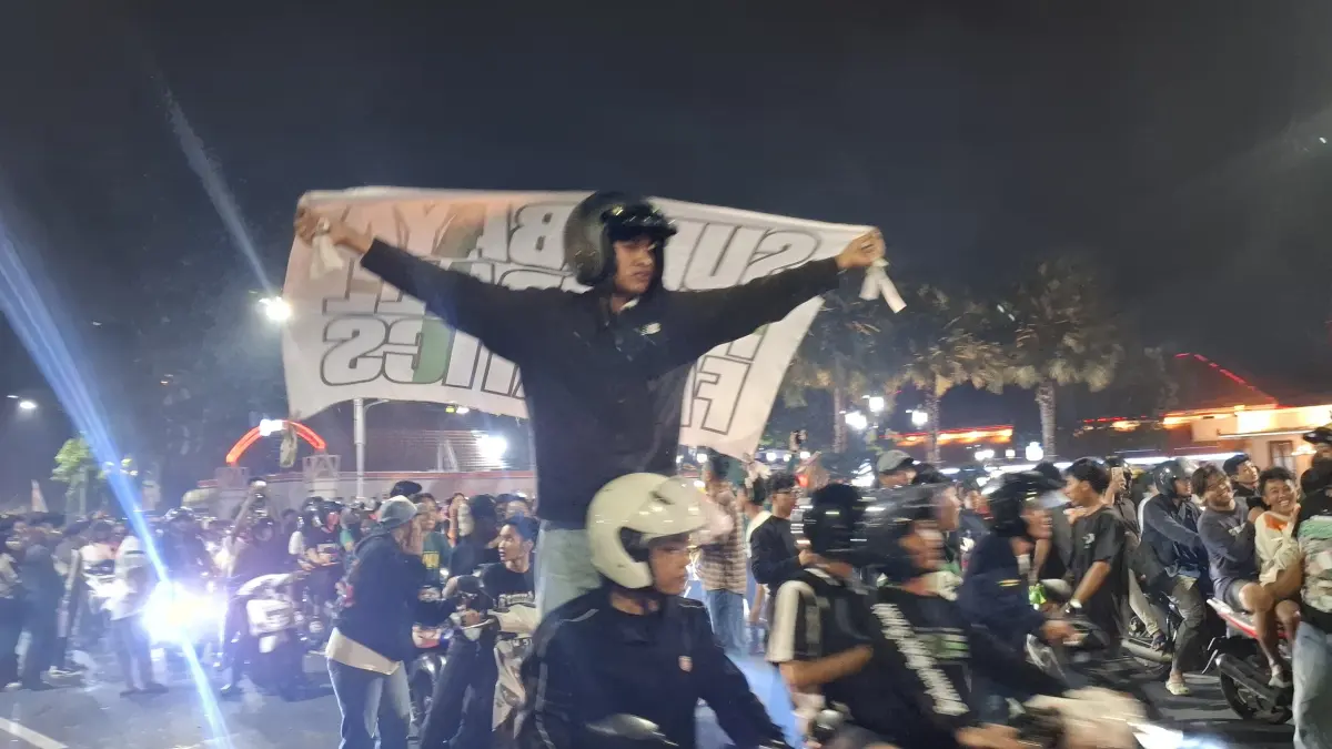 MERIAH: Ribuan suporter bonek memenuhi Jalan Gubernur Suryo, Surabaya, depan Gedung Negara Grahadi. Mereka menyalakan flare hingga kembang api.(GUNTUR IRIANTO/RADAR SURABAYA)