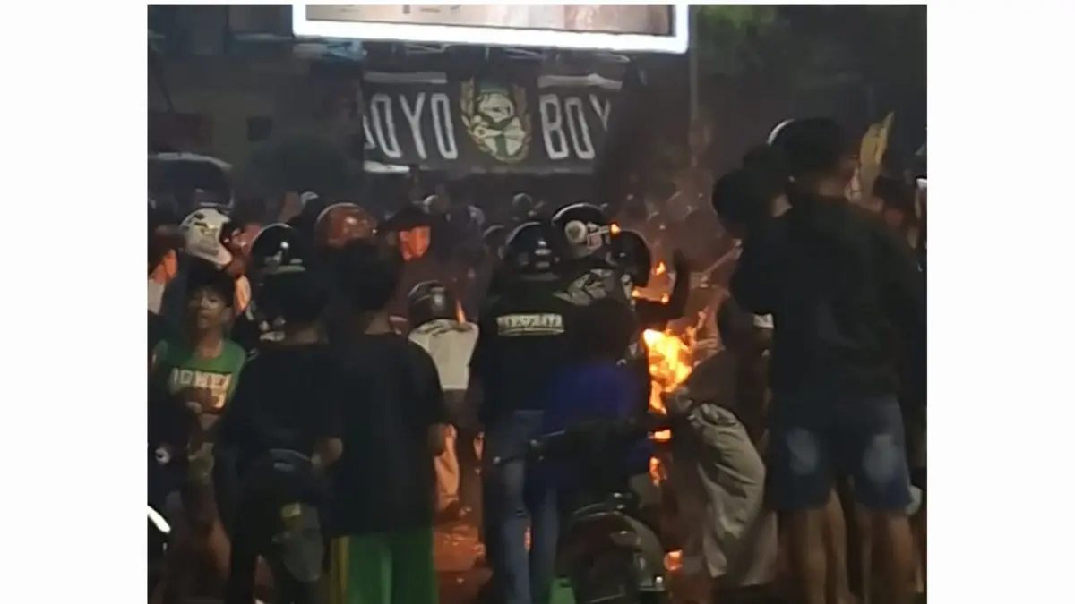 KEPANASAN: Salah satu sepeda motor suporter yang digunakan konvoi terbakar di Jalan Joyoboyo, Surabaya. (MAHRUS/RADAR SURABAYA)