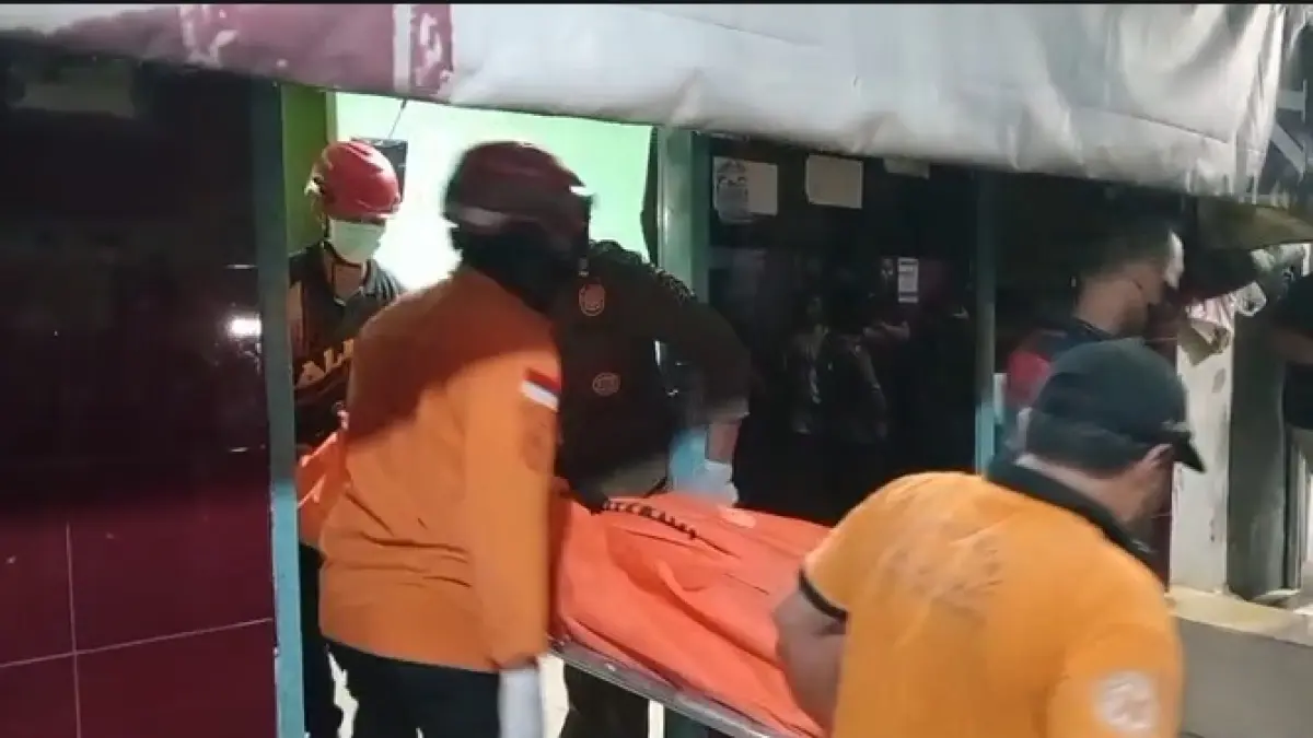 EVAKUASI: Petugas saat membawa jasad korban pembunuhan di rumah kontrakan Jalan Putat Jaya Gang Lebar A, Surabaya.(MAHRUS/RADAR SURABAYA)