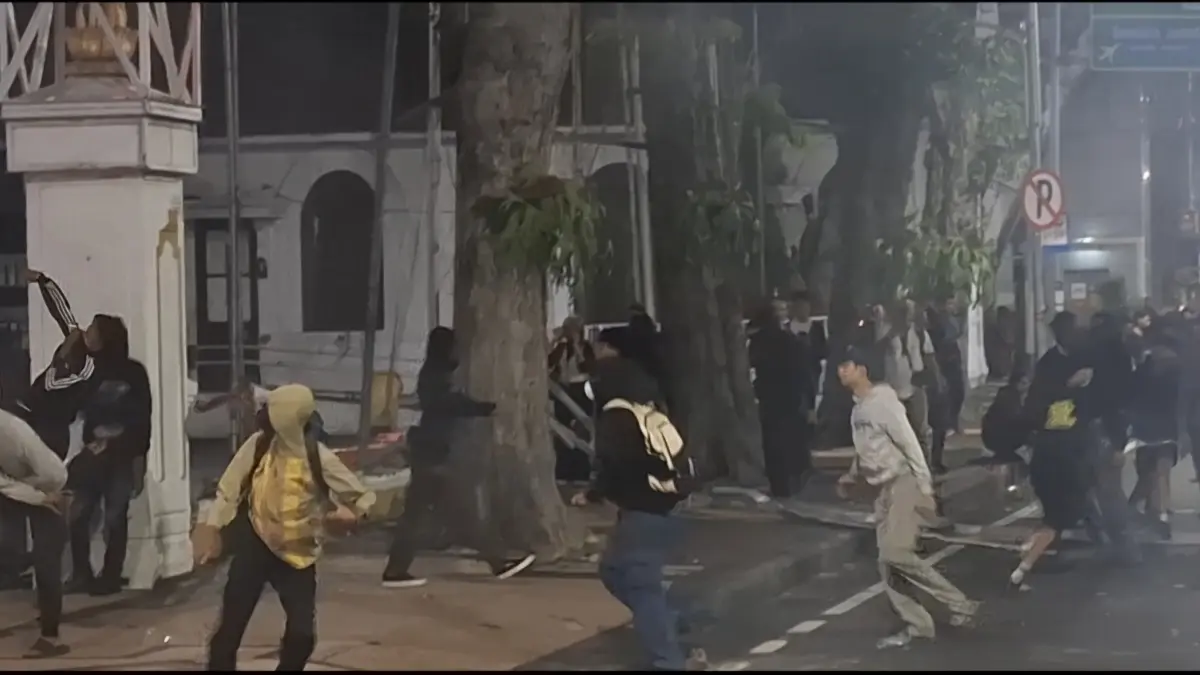 MENYERANG: Massa aksi saat melemparkan galvalum di depan Gedung Negara Grahadi, Surabaya. (I/RADAR SURABAYA)