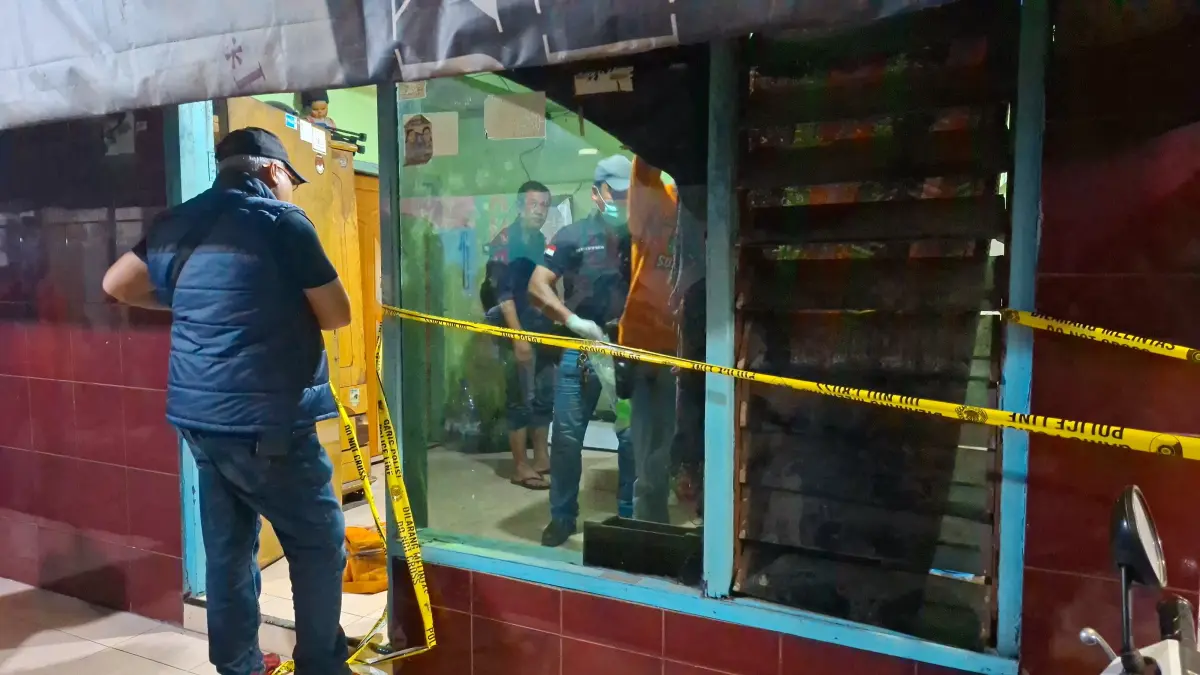 PENYELIDIKAN: Garis polisi terpasang di depan rumah Jalan Putat Jaya Gang Lebar, Surabaya. Seorang perempuan ditemukan bersimbah darah diduga dibunuh di rumah kontrakan.(MAHRUS/RADAR SURABAYA)