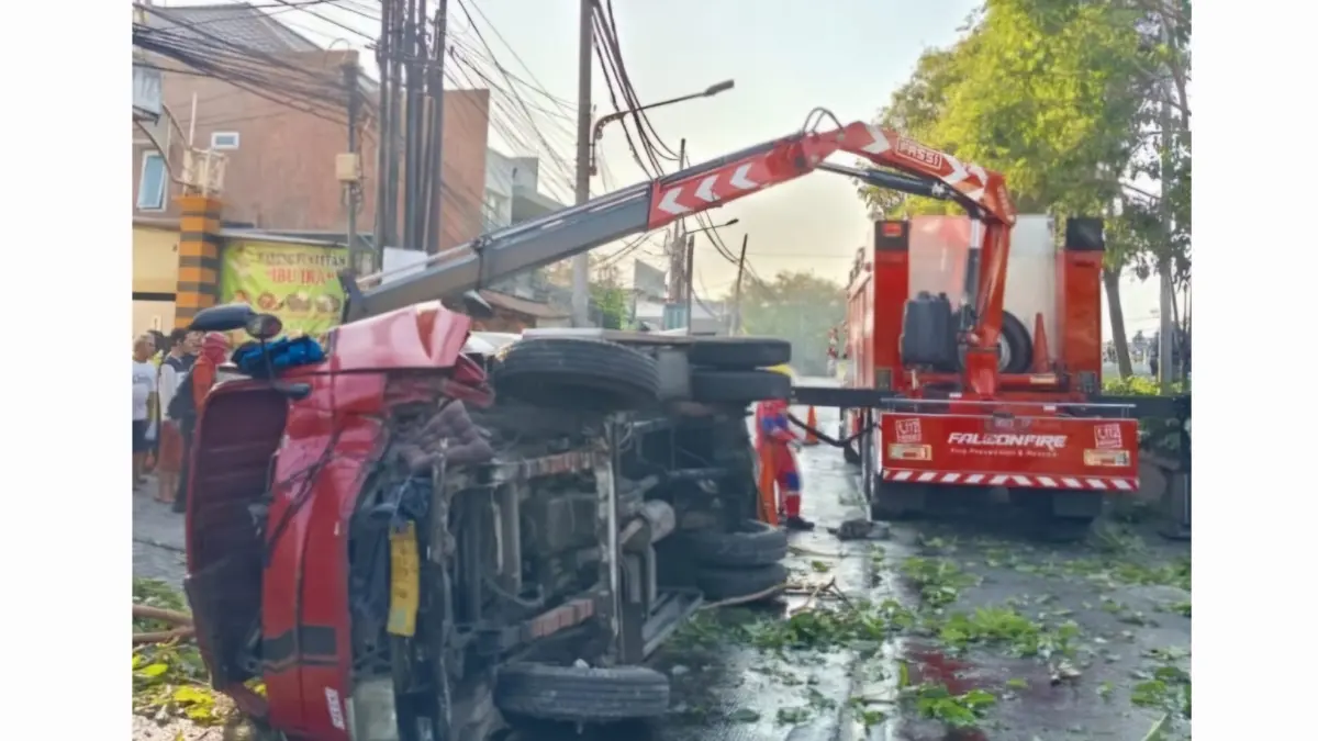 MELINTANG: Kondisi truk tangki saat terguling usai menabrak pohon di Jalan Banjar Sugihan, Surabaya.(IST/RADAR SURABAYA)