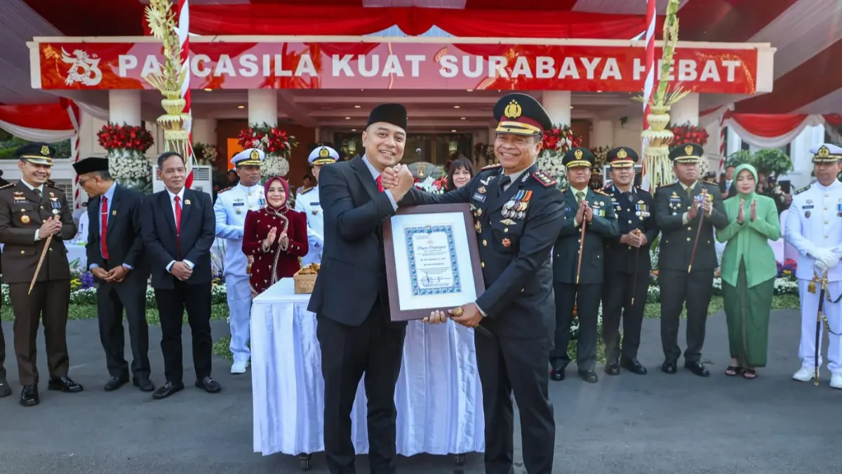 KOMPAK: Kapolrestabes Surabaya Kombes Pol Lutfhie Sulistiawan memberikan penghargaan pada Wali Kota Surabaya Eri Cahyadi saat upacara peringatan Hari Bhayangkara ke-80 di Taman Surya, Balai Kota Surabaya.(IST/RADAR SURABAYA)