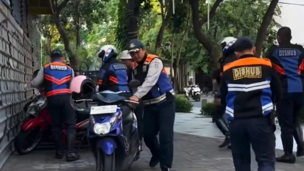 POTENSI TINGGI: Dinas Perhubungan Surabaya saat membantu menertibkan penataan parkir di kawasan Kota Pahlawan.
