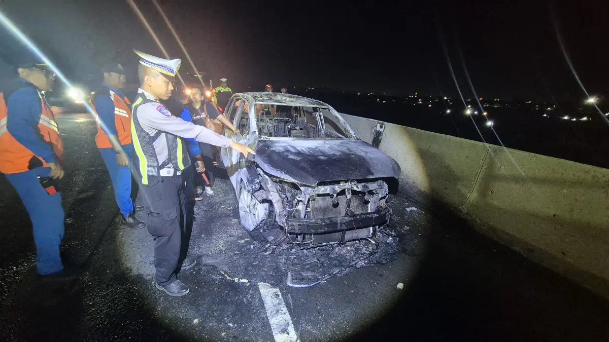 HANGUS : Satu unit mobil Toyota Innova Zenix yang disopiri perempuan DS, 39, warga Bojonegoro terbakar di KM 7.600/B ruas Tol Gresik arah Surabaya, Sabtu (4/7) malam.(IST/RADAR SURABAYA)