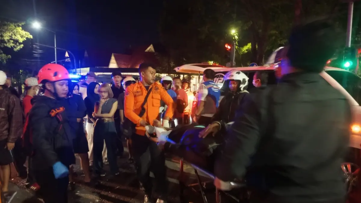 SIGAP: Petugas saat mengevakuasi korban kecelakaan antara motor dan mobil di Jalan Diponegoro, Surabaya. (IST/RADAR SURABAYA)