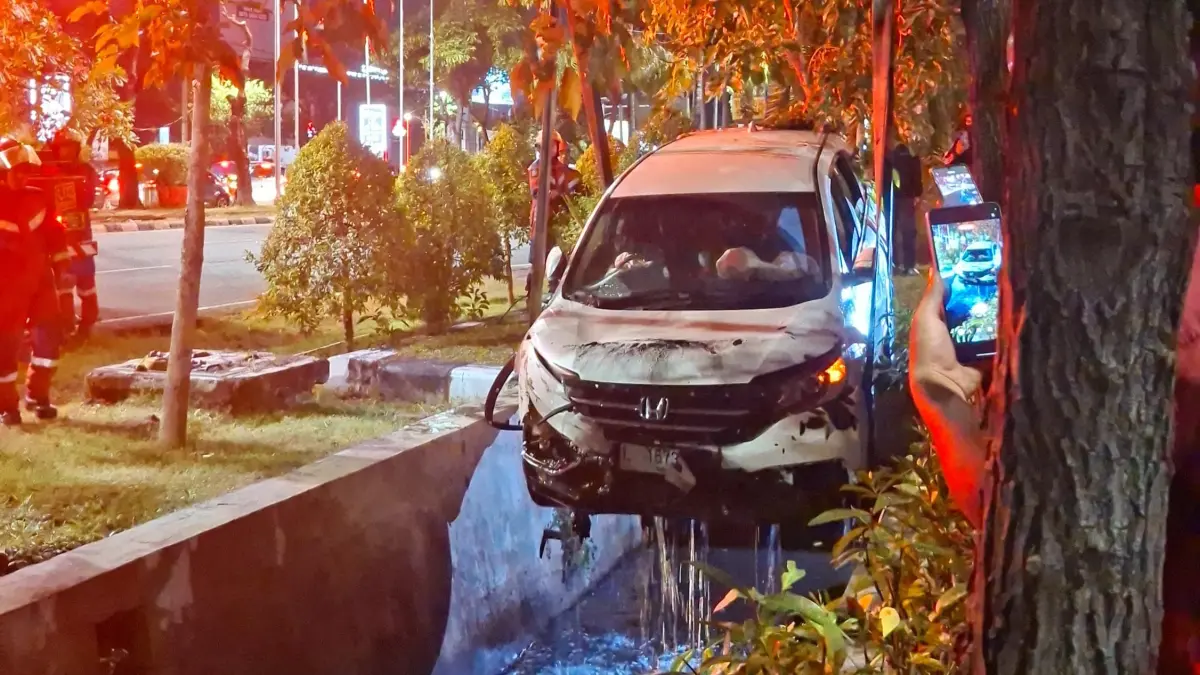 DIANGKAT: Mobil yang tercebur di Jalan Ahmad Yani, Surabaya, saat dievakuasi petugas.(MAHRUS/RADAR SURABAYA)