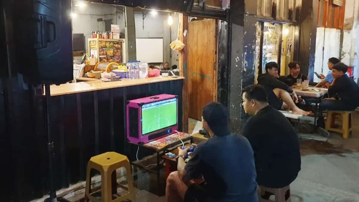 NYANTAI: Salah seorang pembeli di warkop main PlayStation (PS) Box. (M MAHRUS/RADAR SURABAYA)
