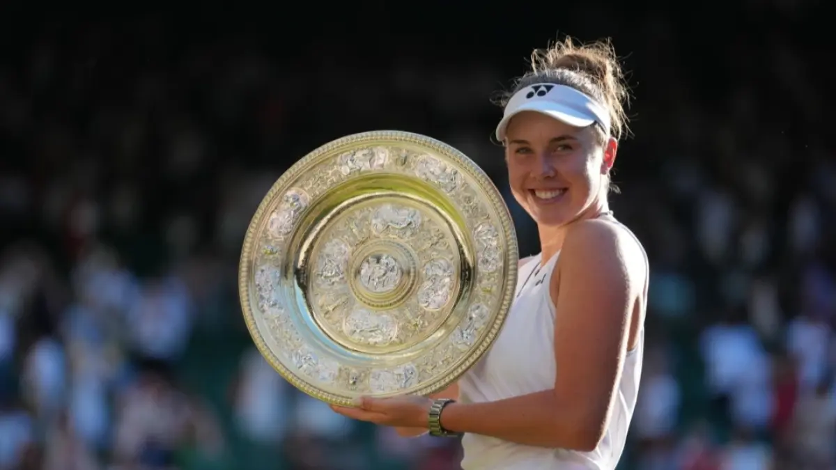 Linda Noskova dari Republik Ceko berpose sambil mengangkat trofi setelah mengalahkan Karolina Muchova, sesama petenis asal Republik Ceko, pada final tunggal putri Kejuaraan Tenis Wimbledon di London, Sabtu (11/7). (Foto: AP/Kirsty Wigglesworth)