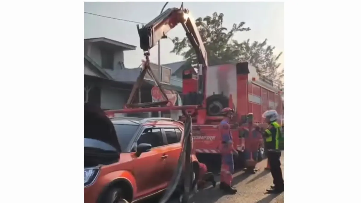 EVAKUASI: Petugas DPKP Surabaya saat mengevakuasi mobil yang tersangkut median di Jalan Karang Tembok, Surabaya. (IST/RADAR SURABAYA)