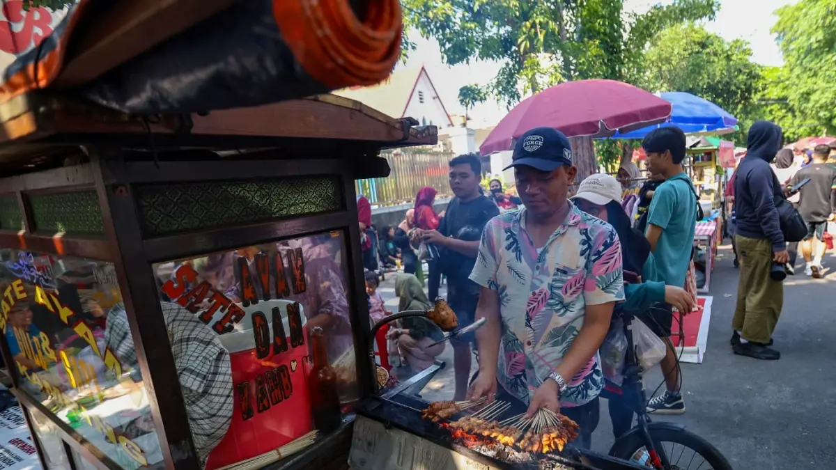 BAKAR SATE: Suasana di kawasan Car Free Day (CFD) Taman Bungkul setiap Minggu pagi selalu ramai. (DIMAS MAHENDRA/RADAR SURABAYA)