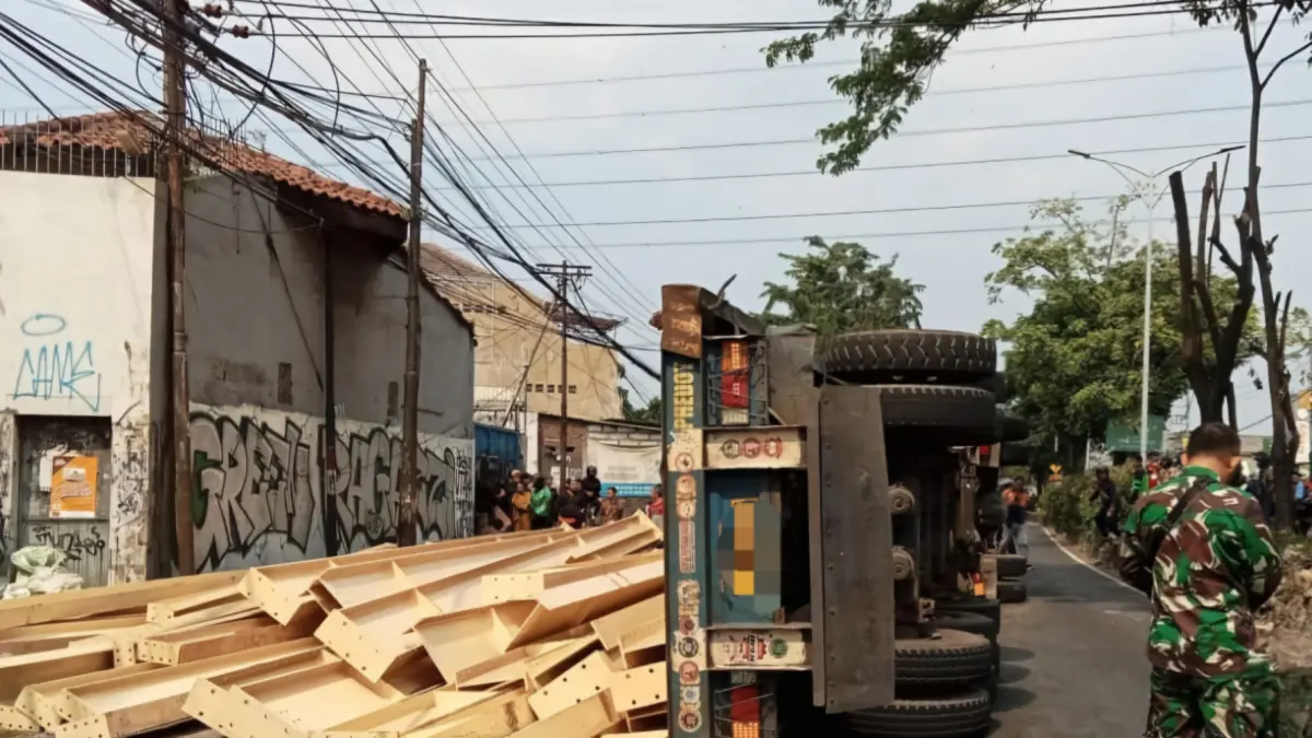 AMBROL: Muatan besi kanal yang terjatuh usai pengikat putus dan menyebabkan truk terguling di Jalan Sukomanunggal, Surabaya.(IST/RADAR SURABAYA)