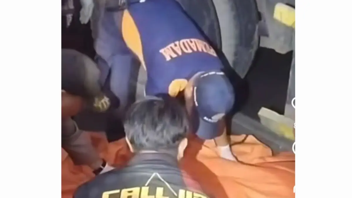 DIEVAKUASI: Petugas saat mengevakuasi pengendara motor yang terlindas truk trailer di Jalan Perak Timur, Surabaya. (IST/RADAR SURABAYA)