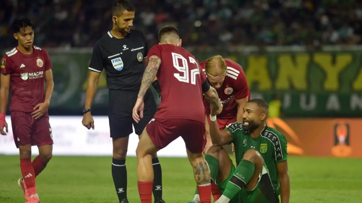 FAIRPLAY: Pemain Persebaya Surabaya, Yuran Fernandes (kanan) dibantu berdiri oleh pemain Persija Jakarta, dalam babak penyisihan grup B Piala Presiden di Stadion Gelora Bung Tomo (GBT) Surabaya, Minggu (26/7).(Andy Satria/Radar Surabaya) 