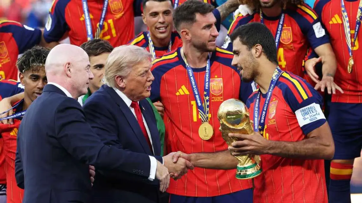 Gianni Infantino dan Donald Trump saat menyerahkan trofi Piala Dunia 2026 kepada kapten timnas Spanyol, Rodri. (ESPN/Carl Recine/Getty Images)