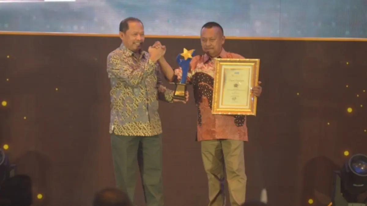 Ketua PWI Jawa Timur Lutfi L Hakim (kanan) menerima penghargaan yang diserahkan Direktur Radar Surabaya, Lilik Widiantoro. (Andy Satria/Radar Surabaya) 