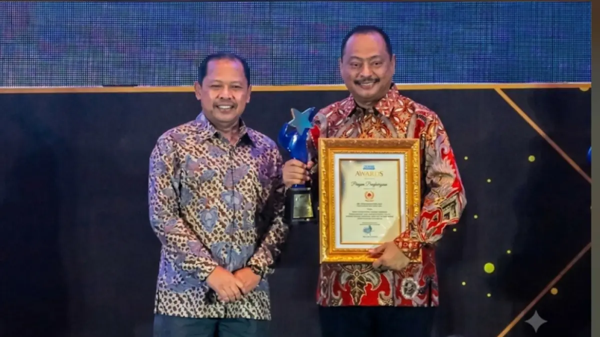 Ketua Umum KONI Jawa Timur Muhammad Nabil (kanan) menerima penghargaan yang diserahkan Direktur Radar Surabaya, Lilik Widiantoro. (Suryanto/Radar Surabaya) 