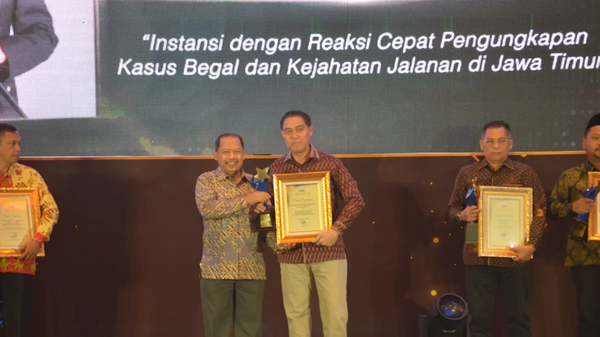 APRESIASI: Kabid Humas Polda Jatim Kombes Pol Jules Abraham Abast mewakili Kapolda Jatim Irjen Pol Nanang Avianto saat menerima penghargaan Radar Surabaya Awards 2026 di Ballroom Hotel Vasa. (ANDY SATRIA/RADAR SURABAYA)