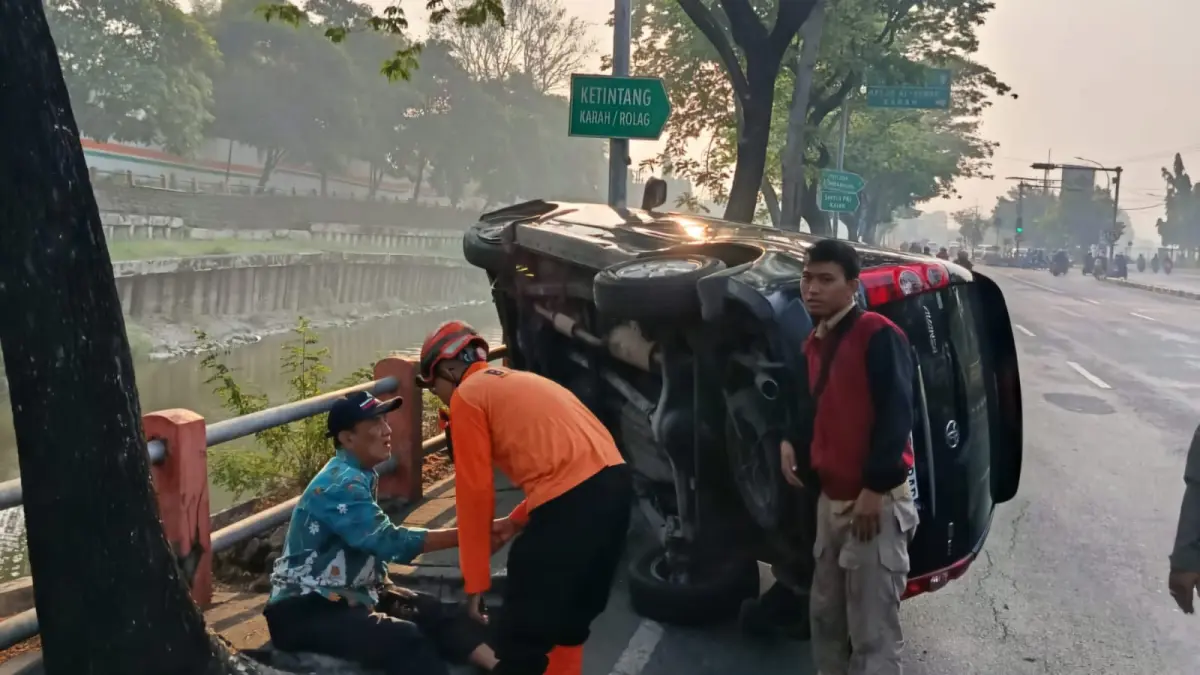 DIEVAKUASI : Petugas Tim Rescue DPKP Surabaya mengevakuasi mobil milik N yang terguling di Jalan Gunungsari Surabaya, Sabtu (1/8).(IST/RADAR SURABAYA)