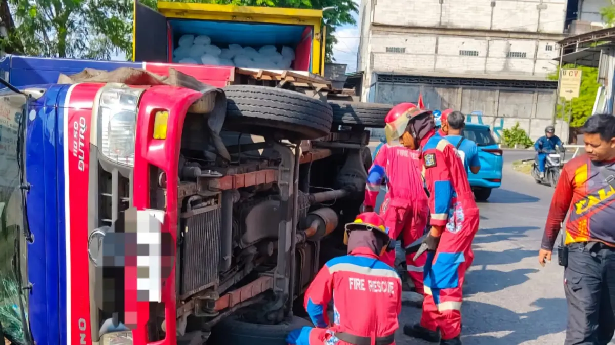 EVAKUASI: Petugas DPKP Surabaya saat mengevakuasi truk boks yang terguling di Jalan Tambak Mayor, Surabaya. (IST/RADAR SURABAYA)