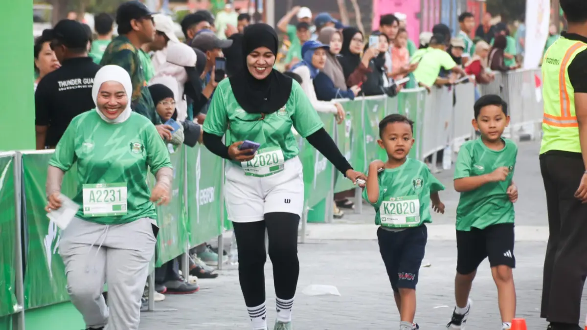 KOMPAK – Orang tua dan anak mengikuti Family Run 2,5K di Kampus Unesa Lidah Wetan, Surabaya, Minggu (2/8). Kegiatan ini diikuti 6.000 peserta dan mengampanyekan gaya hidup sehat melalui olahraga bersama keluarga. (Andy Satria/Radar Surabaya)