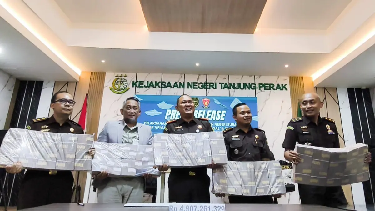DITUNJUKKAN: Kepala Kejari Tanjung Perak Surabaya, Darwis Burhansyah (tengah) memberikan keterangan terkait penyetoran uang sebesar Rp 4,9 Miliar ke kas negara yang diamankan dari TPPU perkara judol, Senin (10/8).(ANDY SATRIA/RADAR SURABAYA)