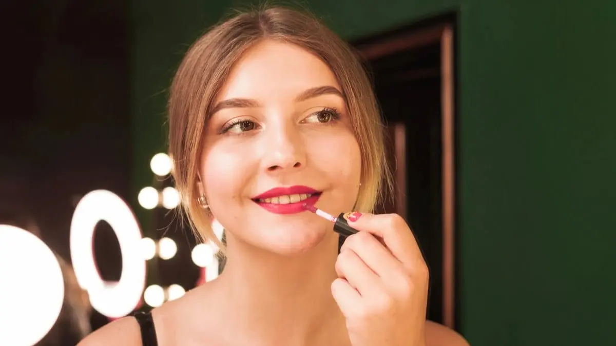Ilustrasi perempuan mengaplikasikan lip tint pada bibir. Penggunaan produk secara tipis dan merata dapat membantu menghasilkan tampilan bibir yang lebih natural. Foto: Ist.