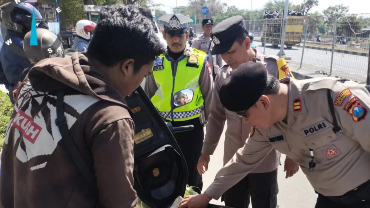 PEMERIKSAAN: Anggota Polsek Kenjeran saat memeriksa barang bawaan salah seorang pengendara di akses masuk Jembatan Suramadu sisi Surabaya.(IST/RADAR SURABAYA)