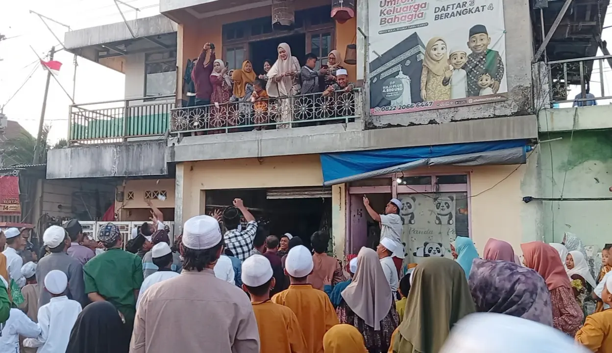 Anak-anak dan warga berebut uang yang dibagikan dari atas rumah saat perayaan Maulid Nabi Muhammad SAW di Kampung Nelayan Cumpat, Surabaya. Tradisi Muludan tersebut masih dilestarikan warga dari tahun ke tahun. (Rahmat Sudrajat) 
